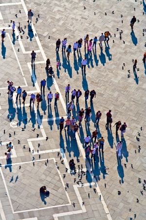 VENICE, ITALY - 04 JULY: Tourists on San Marco square feed large flock of pigeons on July 04, 2007. San Marco square is the largest and most famous square in Venice.のeditorial素材