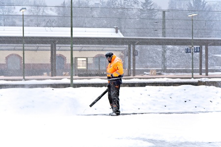 WIESBADEN, GERMANY - DECEMBER 12: Worker is cleaning the train platform from snow in heavy snowstorm  to prevent accidents on December 12, 2010 in Wiesbaden, Germany.のeditorial素材