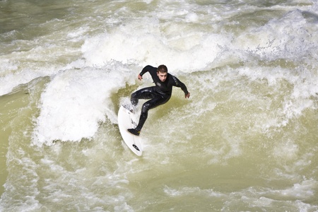MUNICH, GERMANY - APRIL 07: surfer surfs at the Isar in huge waves for season opening event at the Wittelsbacher bridge in the heart of Munich on April 07,2009 Munich, Germany.のeditorial素材