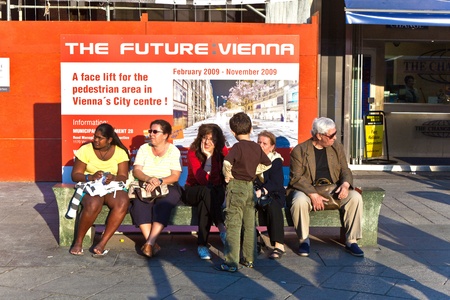 VIENNA, AUSTRIA - APRIL 25: Poster Project Future Vienna stands behind a bemch with people. Vienna informs about activities for facelifting the city on April, 25,2009,  Vienna, Austria.のeditorial素材