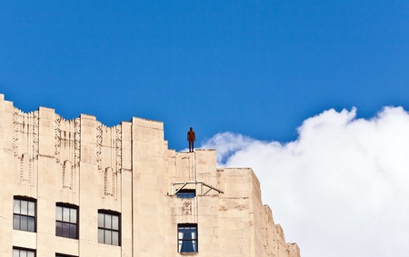 NEW YORK, USA - JULY 7: Facade of Empire State Building in the afternoon with iron statue of Man...