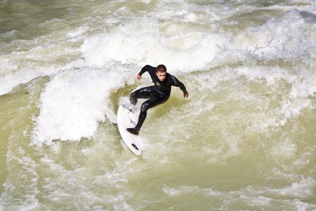 MUENCHEN, GERMANY - APRIL 07: People surfing on the Isar for season opening contest on April 07,2009...