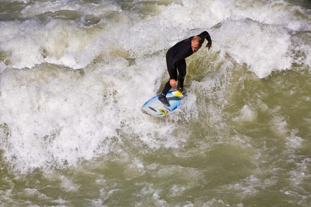 MUENCHEN, GERMANY - APRIL 07: People surfing on the Isar for season opening contest on April 07,2009 Munich. Surfing on the Isar and watching is a famous touristic attraction.のeditorial素材