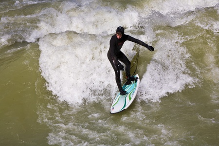 MUENCHEN, GERMANY - APRIL 07: People surfing on the Isar for season opening contest on April 07,2009 Munich. Surfing on the Isar and watching is a famous touristic attraction.のeditorial素材