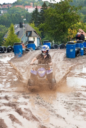 young boy is faszinated by quad driving and enjoyes is, his face is dirty from mudの写真素材