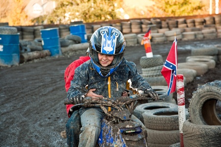 child loves to race with a quad bike at the muddy quad track