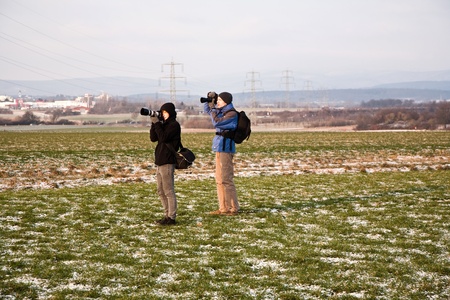 young boys are taking pictures of acres with snow in winter in beautiful light and structureの写真素材