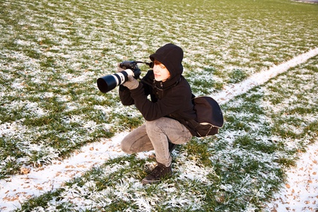 young boys are taking pictures of acres with snow in winter in beautiful light and structureの写真素材