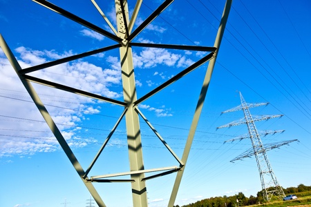 Steel electricity pylon on bright blue skyの写真素材