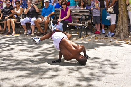 NEW YORK CITY - JULY 9: Brake dancer at an open air performance to tourists at battery park on July 9,2010 in New York City. They ask for a donation to earn money.のeditorial素材