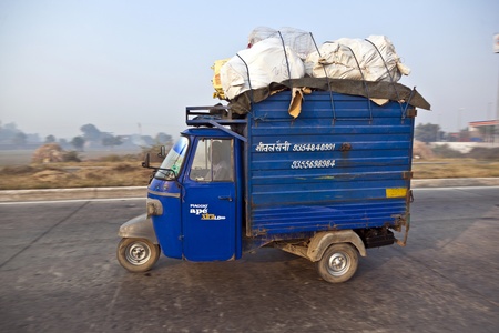 AGRA, INDIA - NOVEMBER 16:  overloaded rickshaw on the Highway on November 16, 2011 near Agra, India. NH2, a modern divided highway, connects the 200 km distance from Delhi to Agra.のeditorial素材