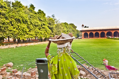 DELHI, INDIA - NOVEMBER 9: female worker carries rock waste on her hat on November 9, 2011 in Delhi, India. 2,057  Mio women work in the construction business (2004) and the figures are increasing.のeditorial素材