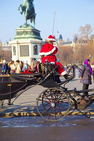 VIENNA, AUSTRIA - NOV 26: driver of the fiaker is dressed as Santa Claus on November 26,2010 in Vienna, Austria. Since the 17th century, the horse-drawn carriages characterize Viennas cityscape.のeditorial素材