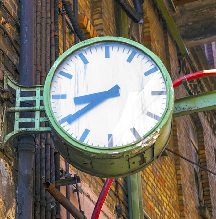 clock in an old abandoned factory at the wall