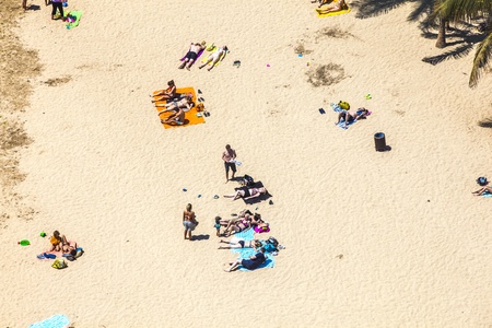 ARRECIFE, SPAIN - APRIL 8: beach with tourists in summer on April 8,2012 in Arrecife, Spain. The beach El Reducto is granted a blue flag by the European Union. This seal for cleanness must renewed yearly.のeditorial素材