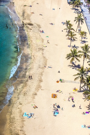 ARRECIFE, SPAIN - APRIL 8: beach with tourists in summer on April 8,2012 in Arrecife, Spain. The beach El Reducto is granted a blue flag by the European Union. This seal for cleanness must renewed yearly.のeditorial素材