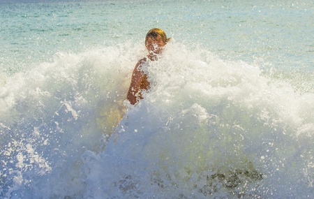 boy has fun surfing in the wavesの写真素材