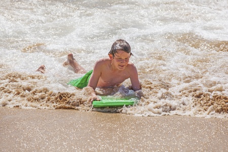 cute boy surfing in the wavesの写真素材