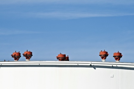 white tanks in tank farm with blue clear sky