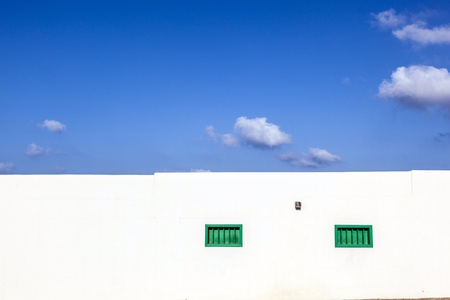 facade of mediterranean house with closed shutterblinds at middayの写真素材