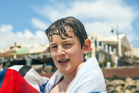 happy boy with towel at the beachの写真素材