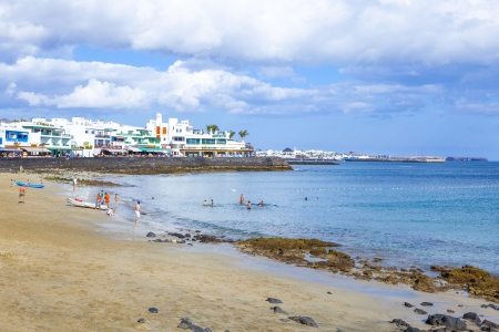 PLAYA BLANCA, SPAIN - APRIL 4: people enjoy the artifical beach Playa Dorada on April 4,2012 in Playa Blanca, Spain. The beach was restored in 2010 with white sand and is the top beach in Lanzarote.の写真素材