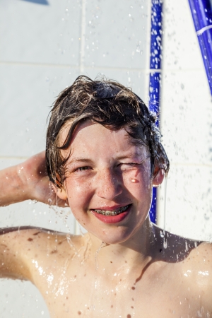 cute boy has fun unter the pool showerのeditorial素材