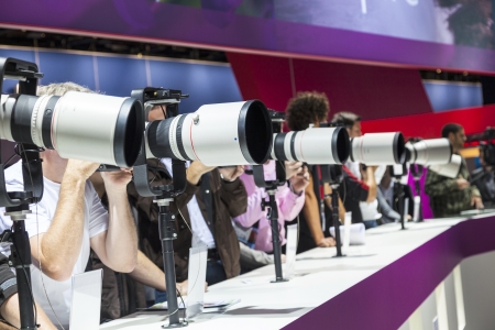 PHOTOKINA, COLOGNE - SEPTEMBER 21: Photokina - World of Imaging, Top Event for the Trade and User, September 21, 2012 in Cologne, Germany. Visitors test huge tele lenses.のeditorial素材