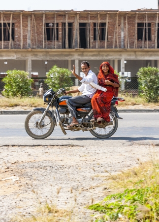 RAJASTHAN, INDIA - OCTOBER 18: Mother, father and small child riding on scooter through busy highway street on October 18, 2012 in Rajasthan, India. Up to six family members manage to ride these two wheelers.のeditorial素材