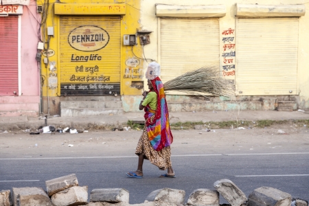 JAIPUR, INDIA - 20 NOVEMBER: woman of fourt class in brightly colored clothing cleans the street on November 20,2012 in Jaipur, India. They earn 300 IRP for two hours paid by the government.のeditorial素材
