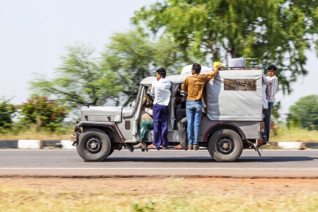 RAJASTHAN - INDIA - OCTOBER 18: Many people in an old indian car on highway on October 18, 2012 in Rajasthan, India. Overloading is the most big problem on indian streets.のeditorial素材