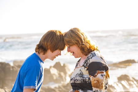 mother and son enjoy the afternoon sun at the beachの写真素材