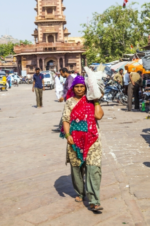JODHPUR, INDIA - OCTOBER 23: woman carrys goods on the shoulder at the Sadar market at the clocktower on October 23,2012 in Jodhpur, India. The imposing Clock Tower was built by Maharaja Sardar Singh (1880-1911).のeditorial素材