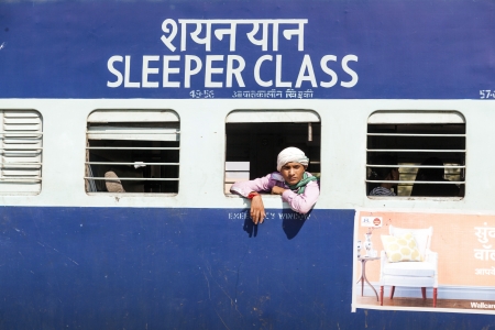 JAIPUR, INDIA - OCTOBER 23: Unidentified passengers hanging at the window of a moving Indian Railway train on October 23,2012 in Jaipur, India. Indian Railways carries  about 7,500 million passengers annually.のeditorial素材