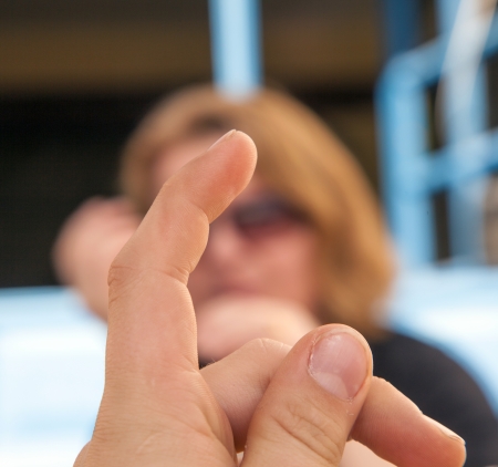 boy gives sign with his finger and making jokesの写真素材