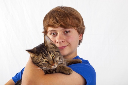 cute boy hugging his cat in the armの写真素材