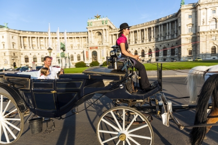 VIENNA, AUSTRIA - JULY 21:  people have a ride in the fiaker and pass the Hofburg on July, 21,2009 in Vienna. The fiaker first was build in the 18 century in the street Rue de Saint Fiacre.のeditorial素材