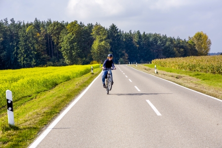 young boy on tour with the bike in rural areaの写真素材