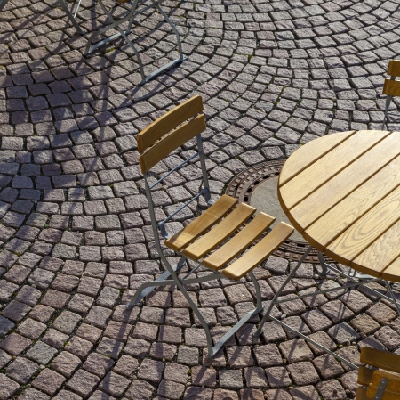 Outdoor German cafe seating with round tables and wooden  chairsの写真素材