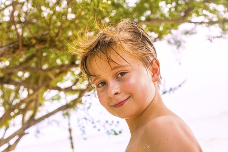 young boy at the beach smilingの写真素材