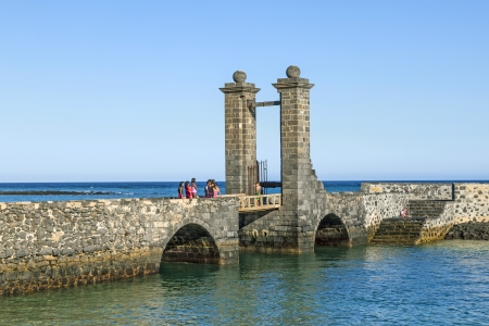 ARRECIFE, SPAIN - MARCH 29: young people have fun at the drawbridge of Castillo de San Gabriel on March 29, 2013 in Arrecive, Spain. The Castillo was built in 1574 in order to defend Arrecife Harbour.のeditorial素材
