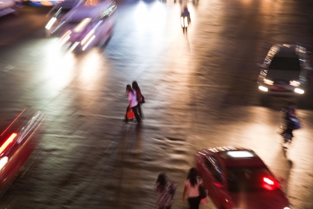 BANGKOK - MAY 6: women cross a mainroad in Bangkok by night on May 6, 2009 in Bangkok Thailand. The population is 8280925 in 2012 in Bangkok and encreases about 7 percent per year.のeditorial素材