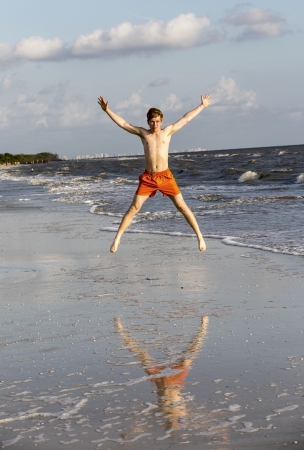 teenager enjoys jogging along the beautiful beachの写真素材