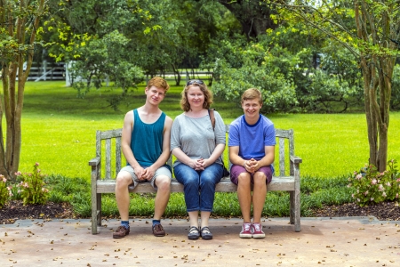 happy family sits in the garden at a bench  and enjoys the natureの写真素材