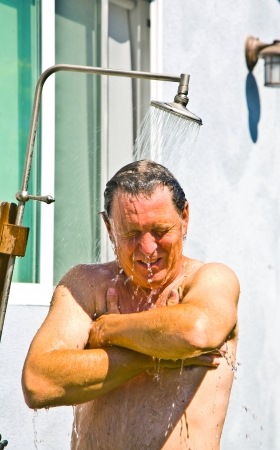 man has a shower in the gardenの写真素材