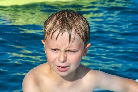 cute boy on a boat is angry and makes a grimaceの写真素材