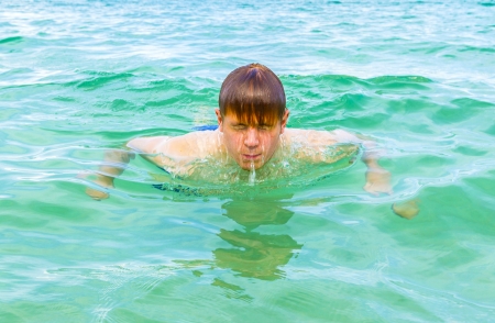 teenage boy enjoys swimming in the oceanの写真素材