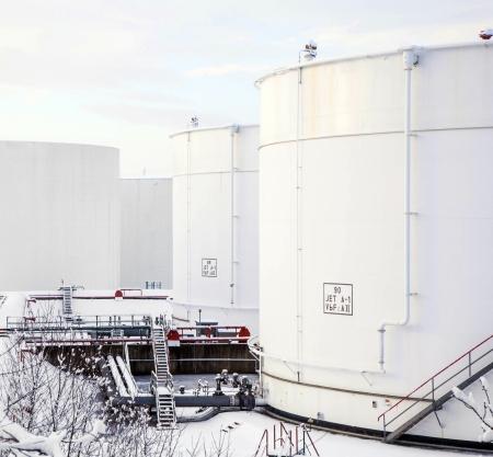 white tanks in tank farm with iron staircase in snow