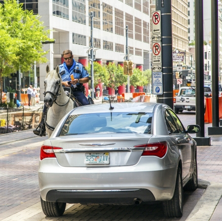 HOUSTON, USA - JULY 11  policeman on horse checks correct parking  on July 11, 2013 in Houston, USA  The HPD mounted patrol has 21 officers and 36 horses のeditorial素材