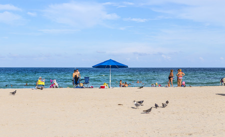 MIAMI, USA JULY 29: Tourists on beach enjoying sun on July 29, 2013 in South Beach Miami. The beach is situated just across the famous Art Deco District Strip.のeditorial素材